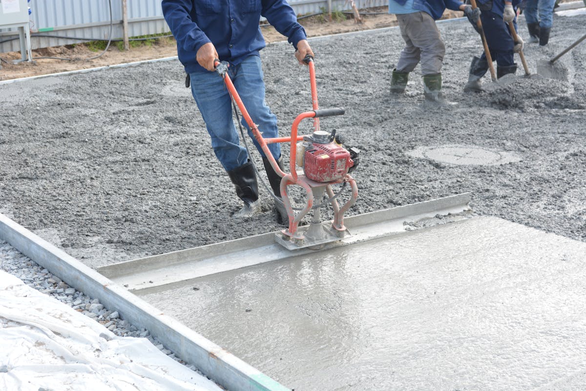 Workers finishing a fresh concrete slab