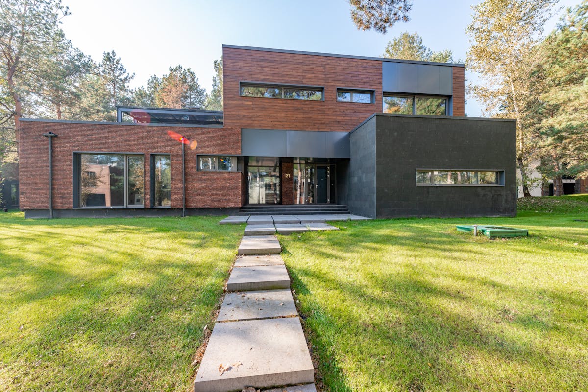 Concrete walkway leading across a lawn to a building entrance